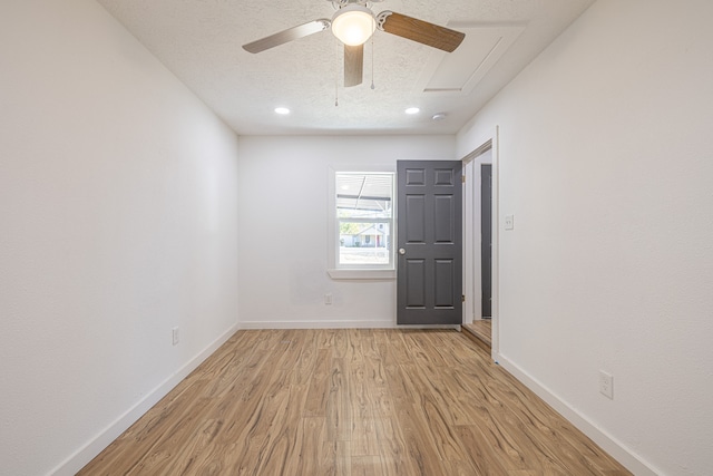 empty room featuring ceiling fan, light hardwood / wood-style floors, and a textured ceiling