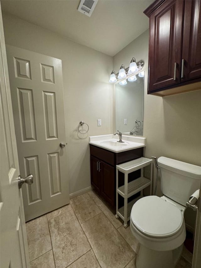 bathroom featuring tile patterned flooring, vanity, and toilet