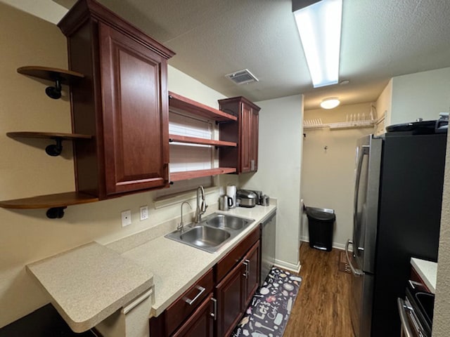 kitchen with a textured ceiling, dark hardwood / wood-style floors, sink, and stainless steel appliances