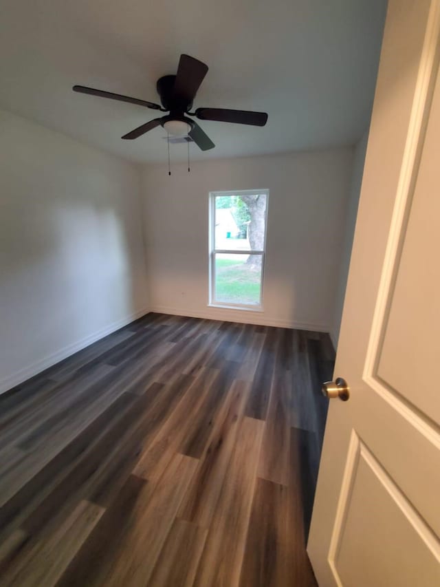 spare room with ceiling fan and dark wood-type flooring