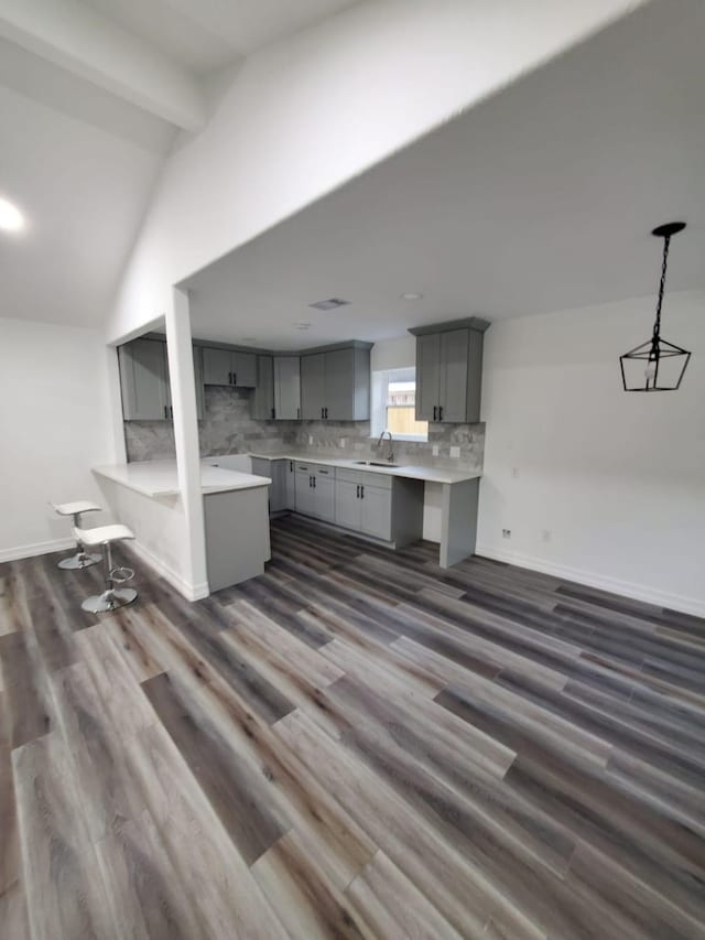 kitchen with sink, hanging light fixtures, dark wood-type flooring, and gray cabinetry