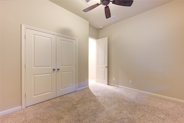 unfurnished bedroom featuring ceiling fan, a closet, and light colored carpet