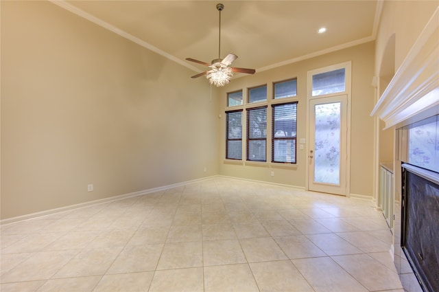 interior space featuring light tile patterned floors, ceiling fan, ornamental molding, and a high ceiling