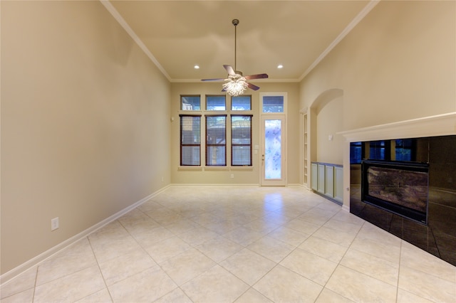 unfurnished living room with ceiling fan, a fireplace, light tile patterned floors, and ornamental molding