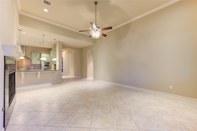 unfurnished living room featuring light tile patterned floors, ceiling fan, and crown molding