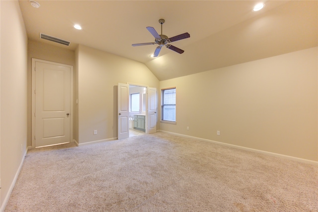 unfurnished bedroom with ceiling fan, light colored carpet, and vaulted ceiling