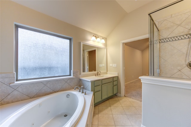 bathroom with tile patterned flooring, vanity, a bathing tub, and vaulted ceiling