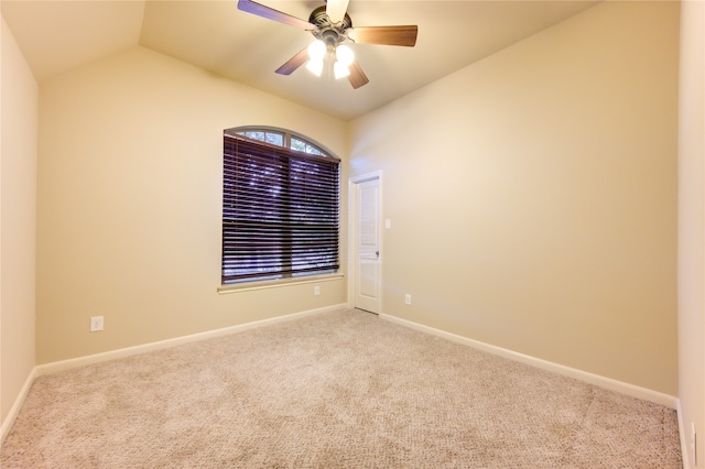 carpeted spare room with ceiling fan and vaulted ceiling