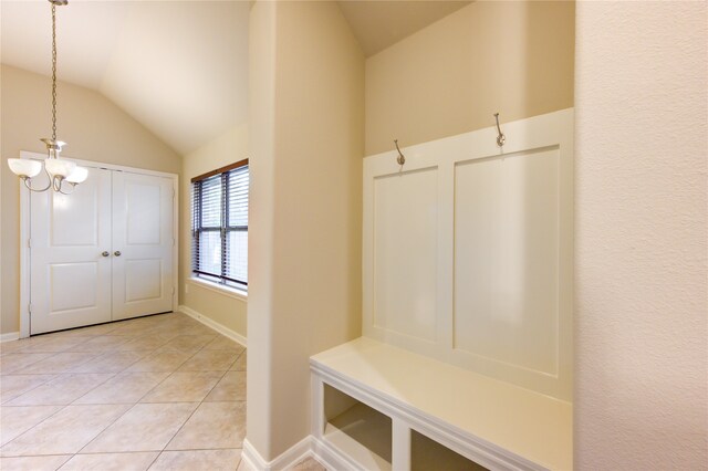 mudroom with light tile patterned floors, a chandelier, and vaulted ceiling