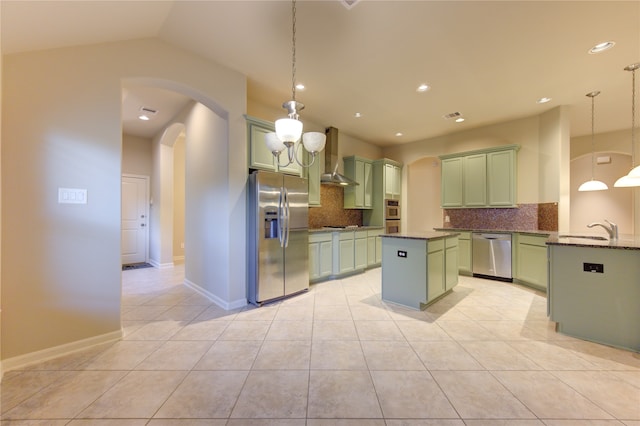 kitchen featuring wall chimney exhaust hood, decorative backsplash, decorative light fixtures, light tile patterned flooring, and stainless steel appliances