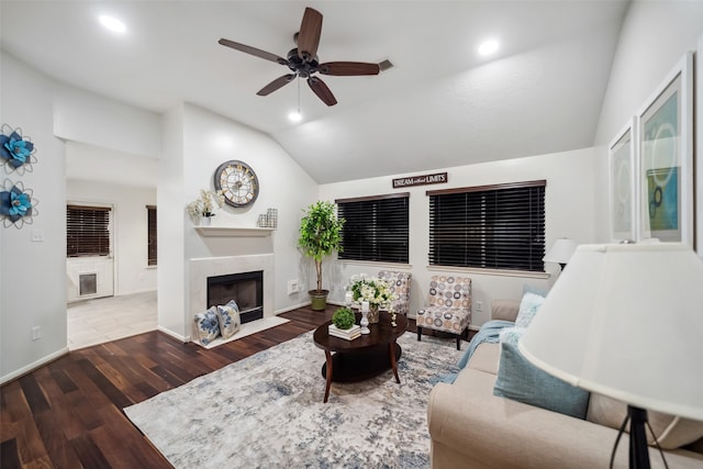 living room featuring a premium fireplace, ceiling fan, dark wood-type flooring, and lofted ceiling