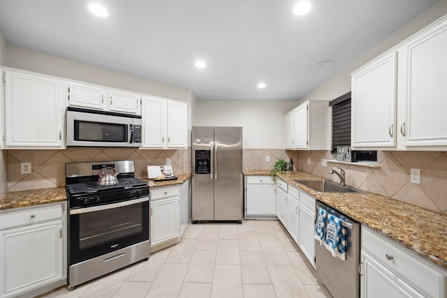 kitchen featuring white cabinets, sink, light stone countertops, and stainless steel appliances