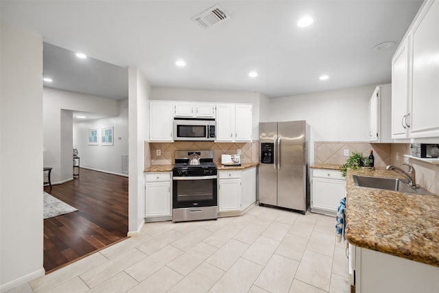 kitchen featuring sink, light hardwood / wood-style flooring, light stone counters, white cabinetry, and stainless steel appliances