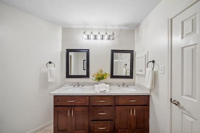 bathroom with a textured ceiling, vanity, and tile patterned floors