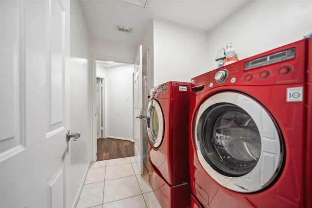 clothes washing area featuring separate washer and dryer and light tile patterned flooring