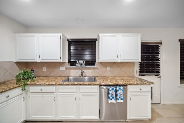 kitchen with backsplash, light stone counters, stainless steel dishwasher, sink, and white cabinetry