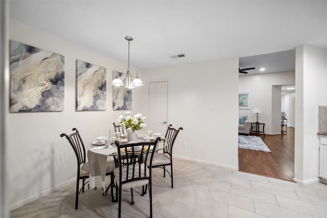 dining space featuring ceiling fan with notable chandelier and light hardwood / wood-style floors