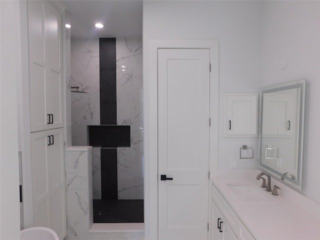 bathroom featuring a tile shower and vanity