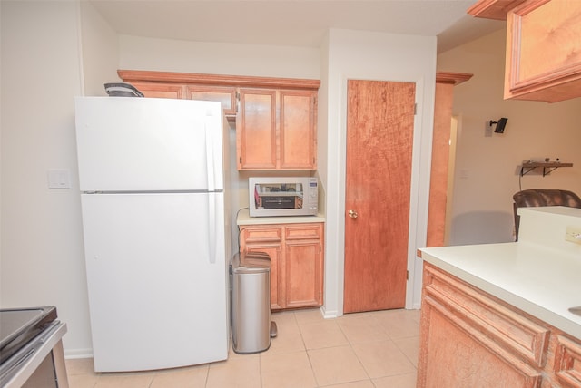 kitchen with light tile patterned flooring, white appliances, and light brown cabinets