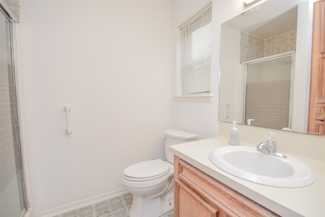 bathroom featuring vanity, toilet, and a shower with door