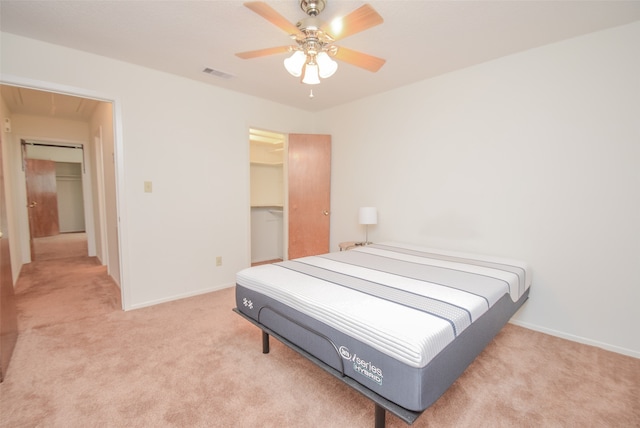 carpeted bedroom featuring ceiling fan, a spacious closet, and a closet