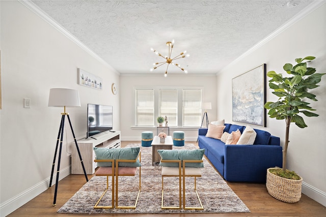 living room with hardwood / wood-style floors, a chandelier, a textured ceiling, and ornamental molding