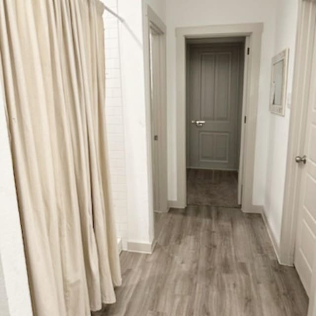 hallway with hardwood / wood-style floors