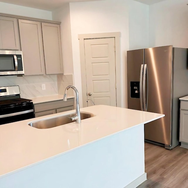 kitchen featuring gray cabinetry, sink, appliances with stainless steel finishes, and light hardwood / wood-style flooring