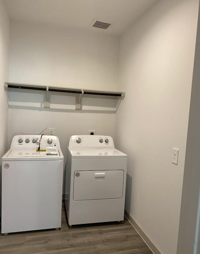 laundry area featuring independent washer and dryer and dark wood-type flooring