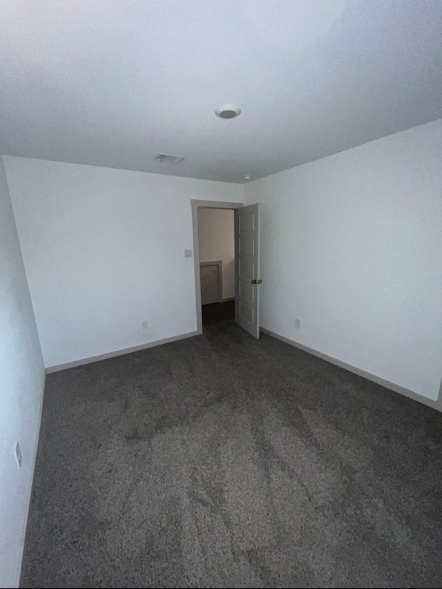 empty room featuring dark colored carpet