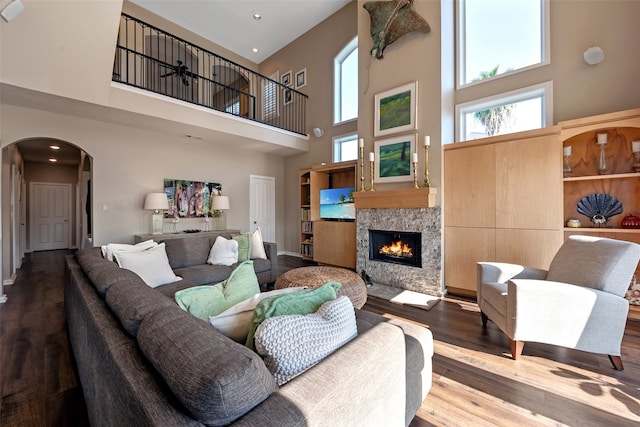 living room with a towering ceiling and hardwood / wood-style flooring