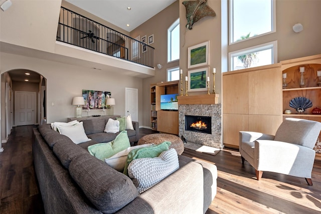 151 Bamaku Bnd, Tiki Island, TX 77554 - living area featuring a high ceiling, arched walkways, wood finished floors, a stone fireplace, and baseboards
