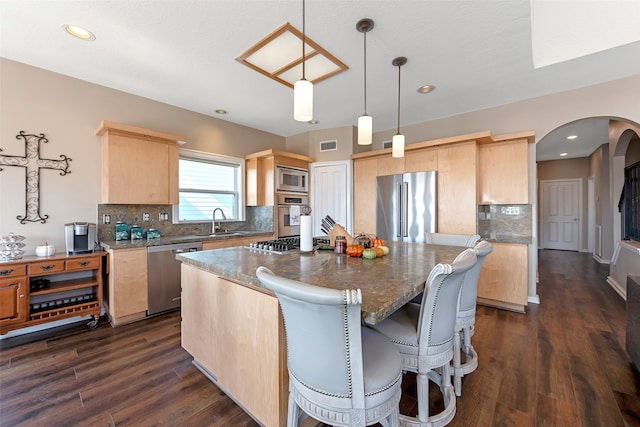 kitchen featuring dark wood-type flooring, light brown cabinetry, and stainless steel appliances