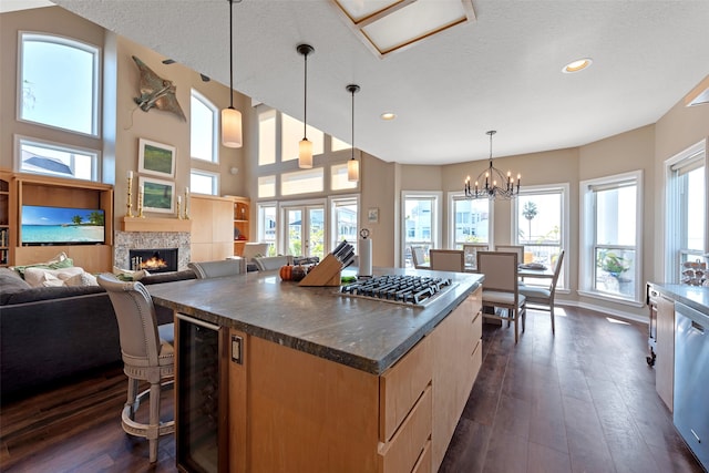 kitchen with decorative light fixtures, stainless steel appliances, a wealth of natural light, and beverage cooler