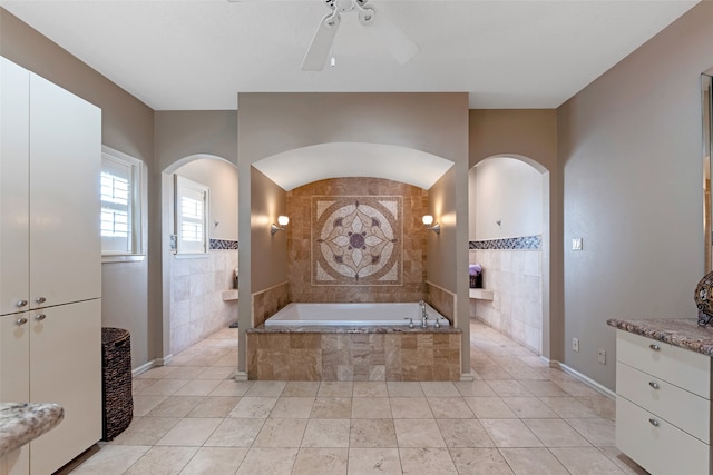 bathroom with vanity, tile patterned floors, ceiling fan, and tiled tub