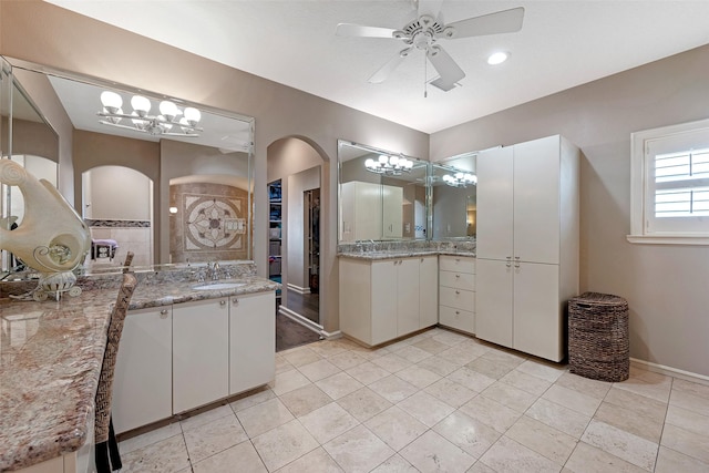 151 Bamaku Bnd, Tiki Island, TX 77554 - bathroom featuring a ceiling fan, two vanities, a chandelier, a spacious closet, and baseboards
