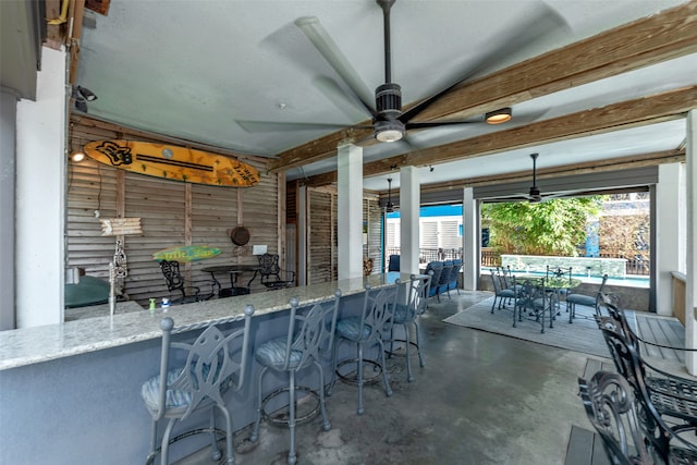 view of patio featuring ceiling fan and exterior bar