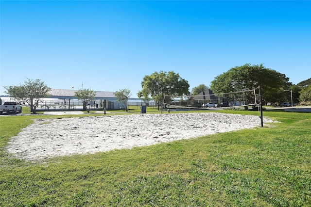 view of home's community with volleyball court and a lawn