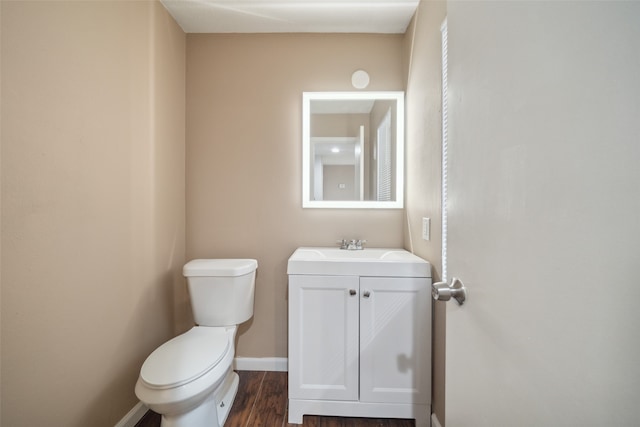 bathroom with hardwood / wood-style floors, vanity, and toilet