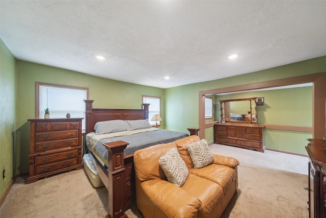 bedroom featuring light carpet and a textured ceiling