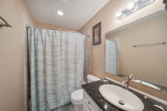 bathroom with curtained shower, vanity, a textured ceiling, and toilet