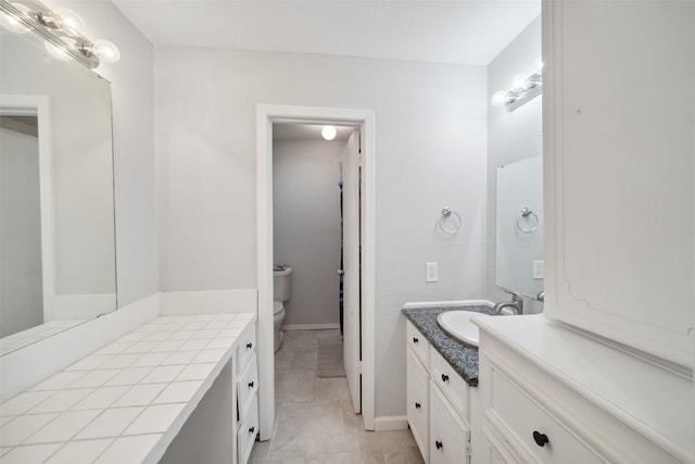 bathroom with tile patterned flooring, vanity, and toilet