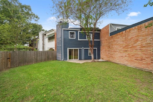 rear view of house with a patio area and a lawn