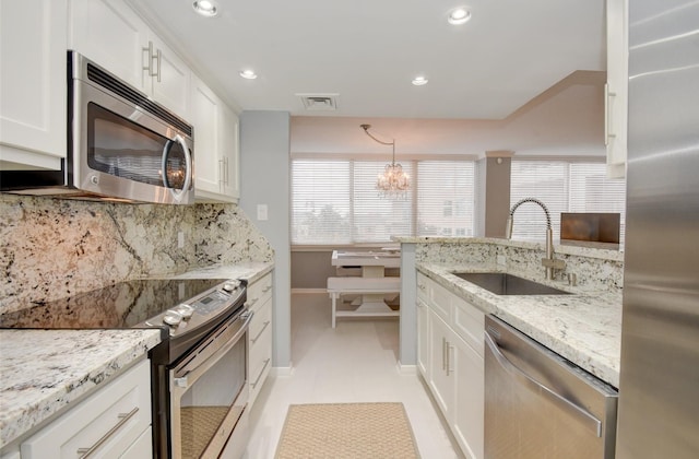 kitchen with tasteful backsplash, a wealth of natural light, white cabinetry, and stainless steel appliances