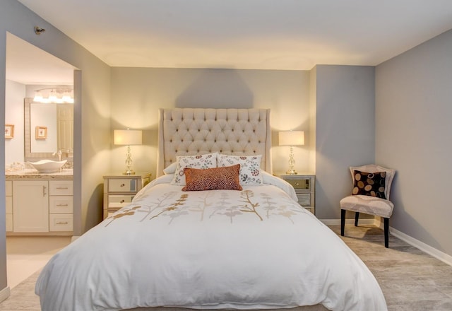 bedroom featuring ensuite bath and sink