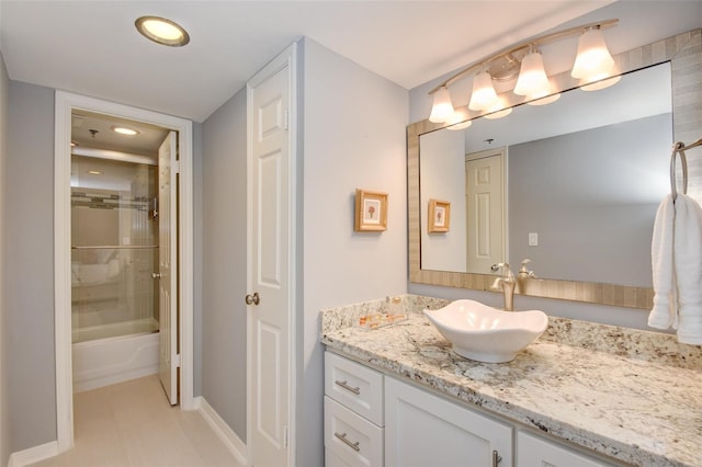 bathroom featuring tile patterned flooring, vanity, and bath / shower combo with glass door