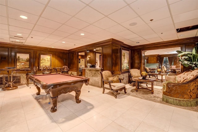 recreation room featuring wooden walls, a drop ceiling, light tile patterned floors, and billiards