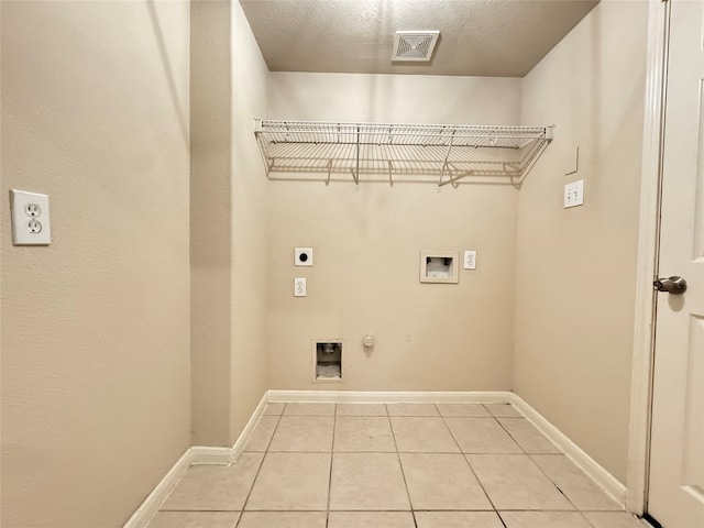 clothes washing area with hookup for an electric dryer, washer hookup, light tile patterned floors, and gas dryer hookup