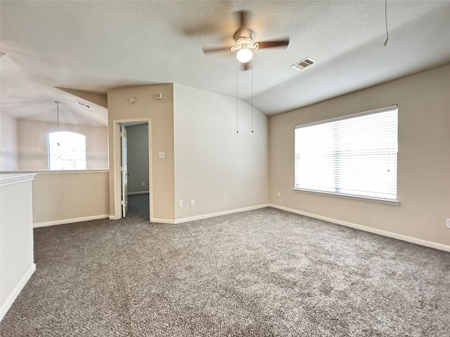 carpeted spare room with a textured ceiling, ceiling fan, and vaulted ceiling