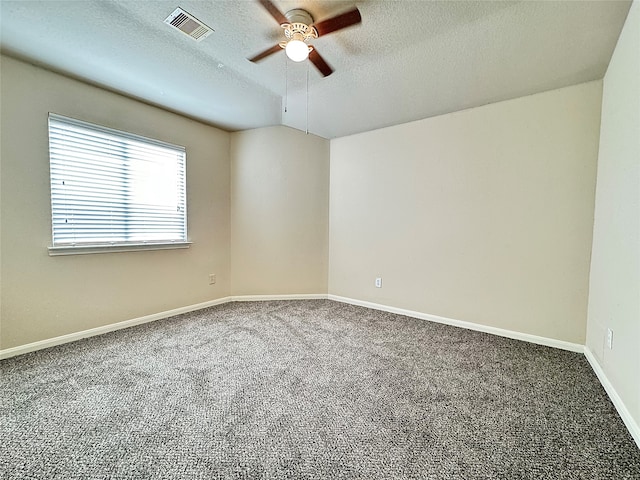 unfurnished room with a textured ceiling, dark carpet, and ceiling fan